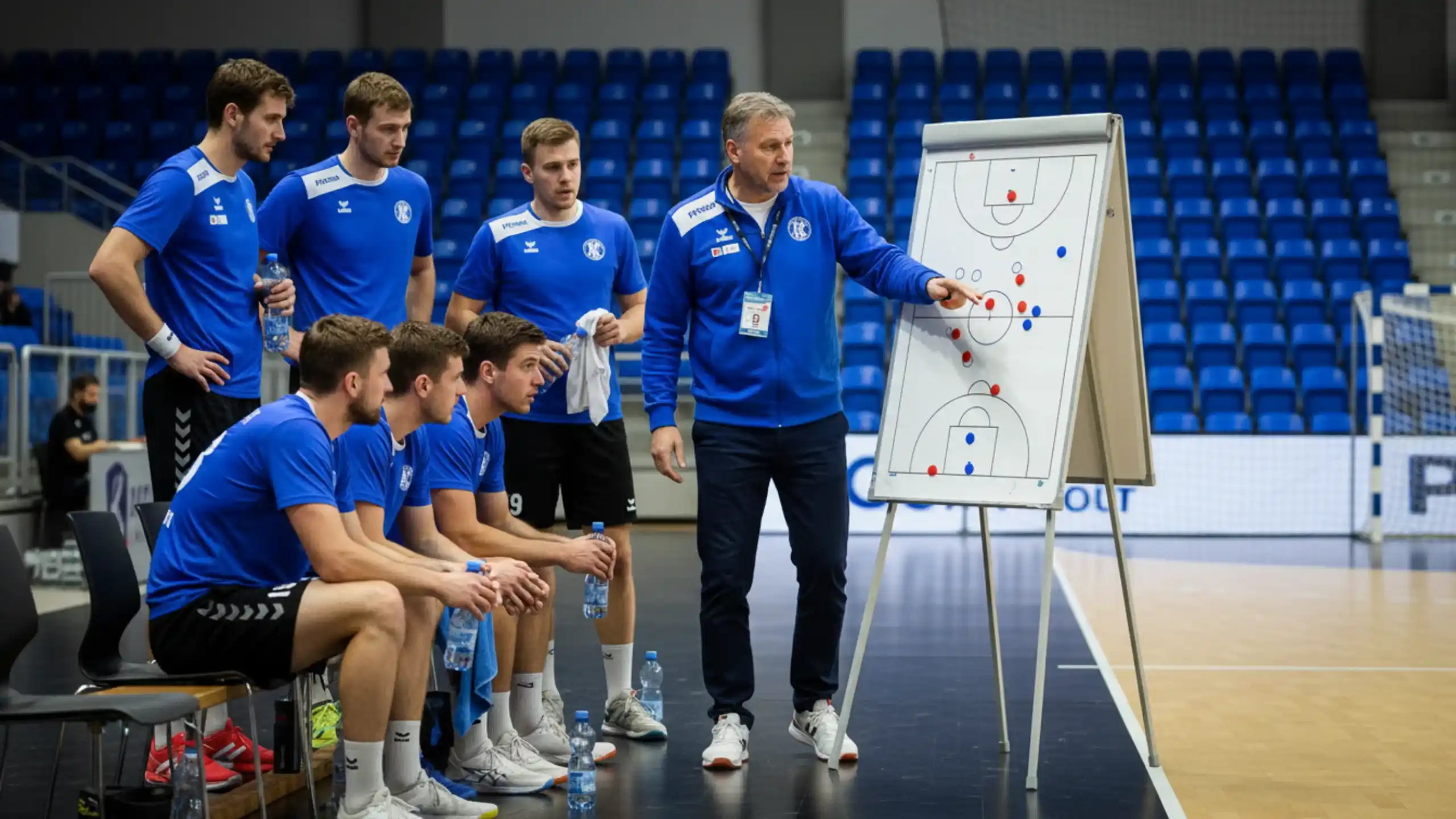 Håndboldtræner analyserer taktik i halvlegspausen